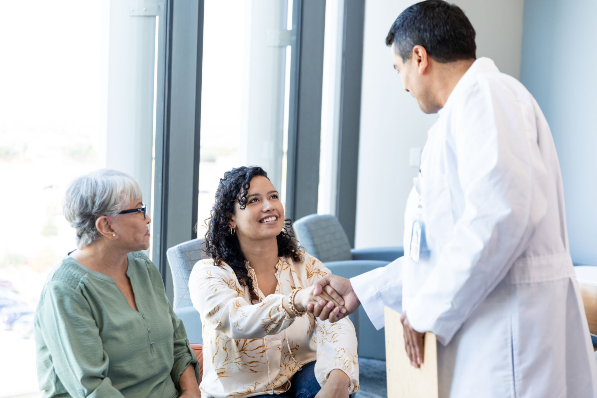 in ER waiting room male doctor greets family members